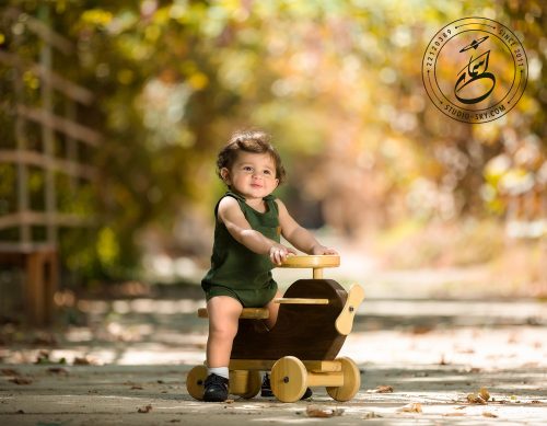عکس کودک با سه چرخه چوبی