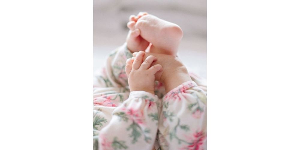 نوزاد در حال بازی با پاهایش
