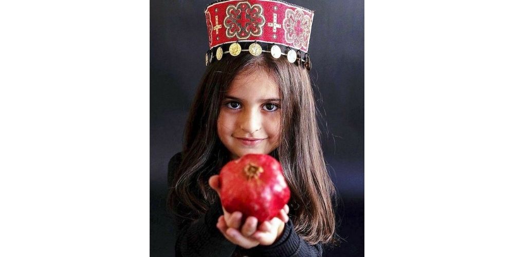 عکس کودک در شب یلدا با میوه انار به سبک پرتره
